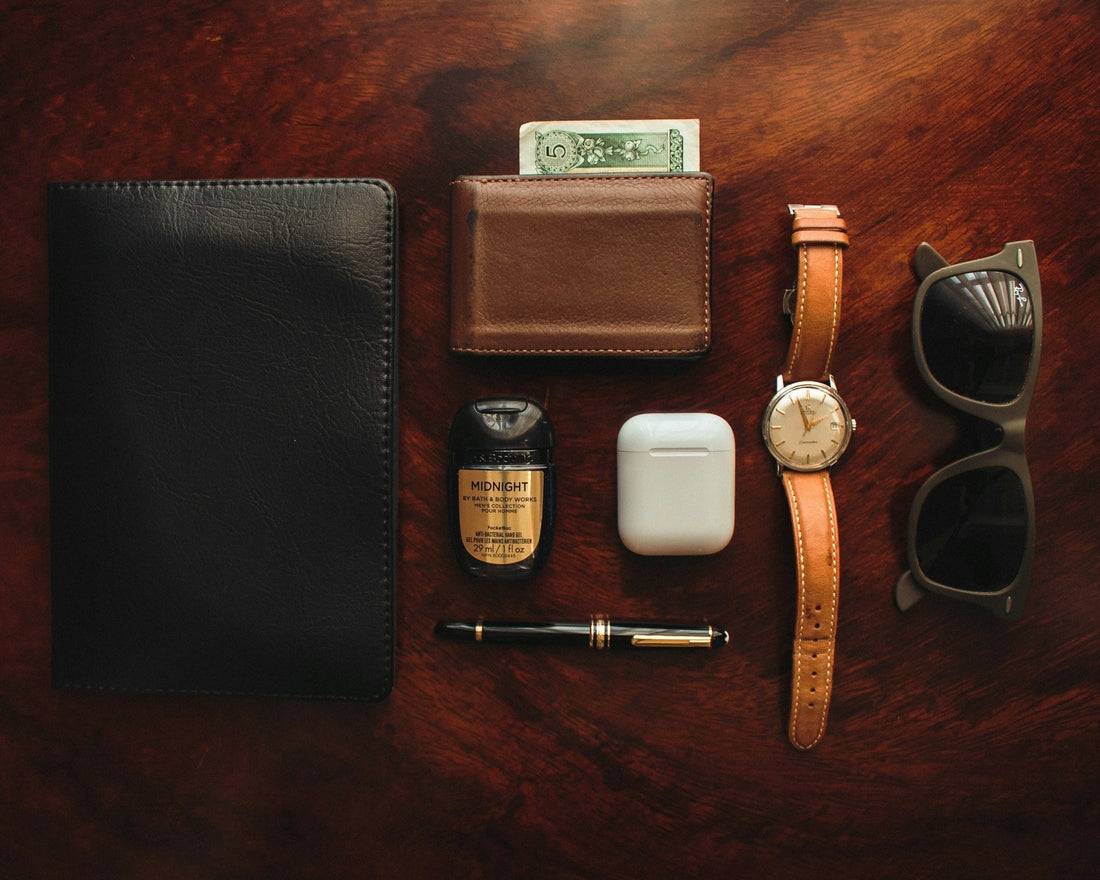 brown leather bifold wallet beside white apple airpods and white apple airpods