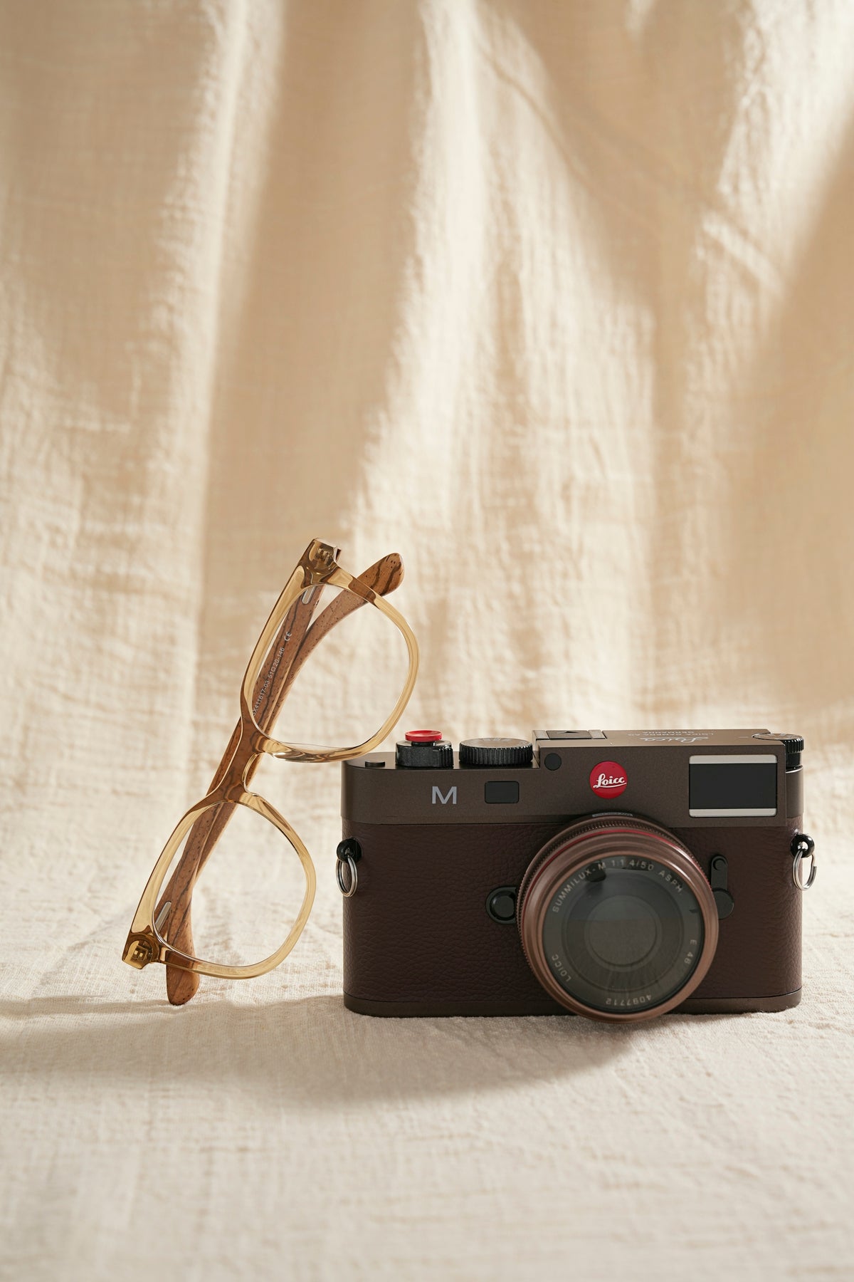 Brown leica camera and glasses on fabric