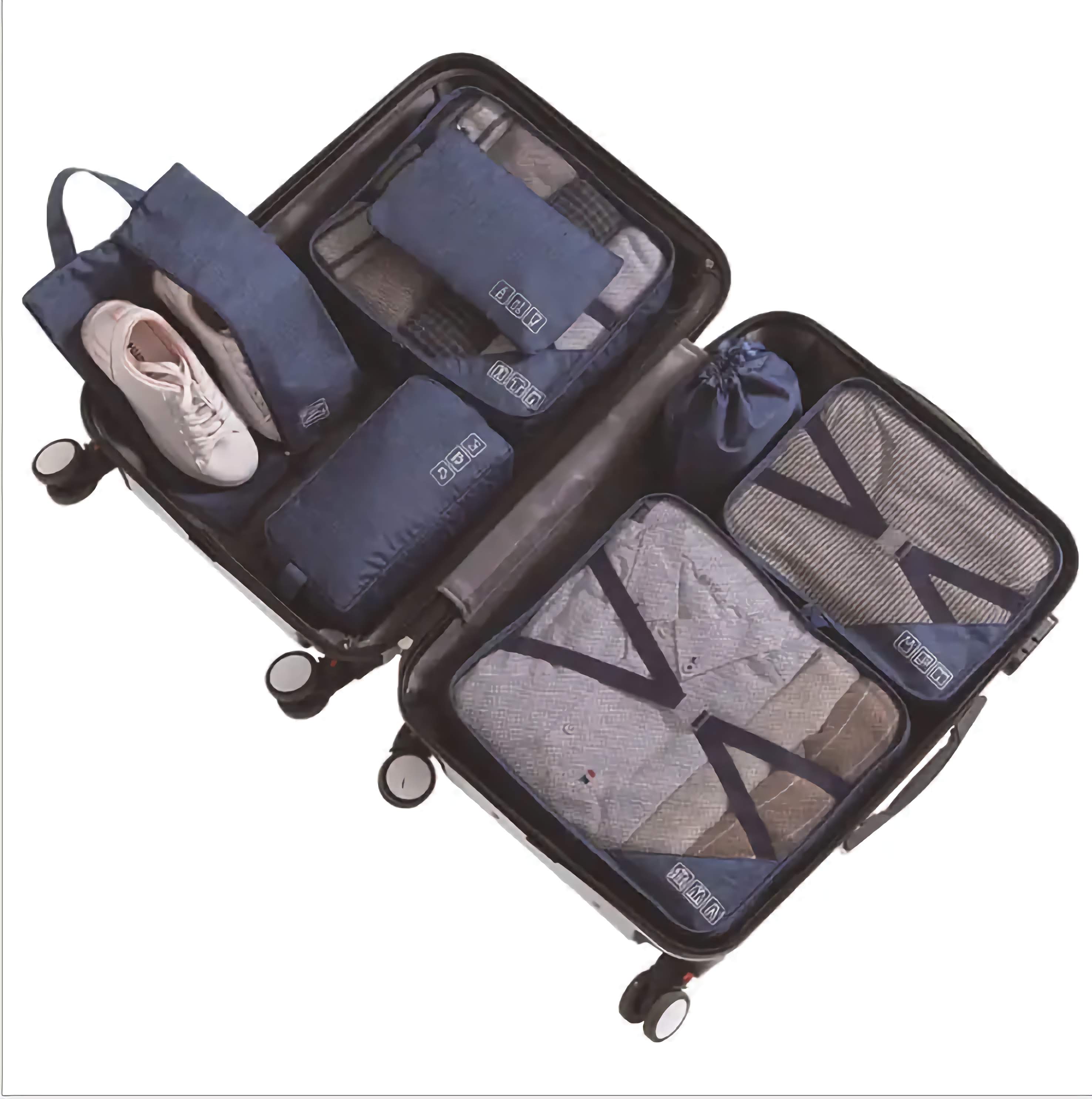Set of blue travel packing cubes with a suitcase on a white background