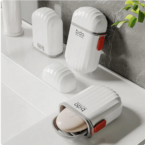 White soap dispensers with red accents on a bathroom counter.