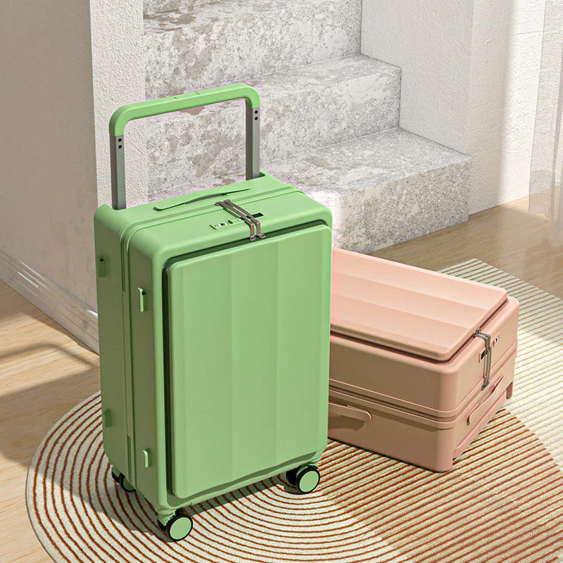 Green suitcase with a pink suitcase in the background on a wooden floor.