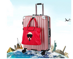 Pink suitcase with a red handbag featuring a face design, airplane, world map, and landmarks in the background.