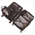 Black suitcase with black travel packing cubes and shoes on a white background