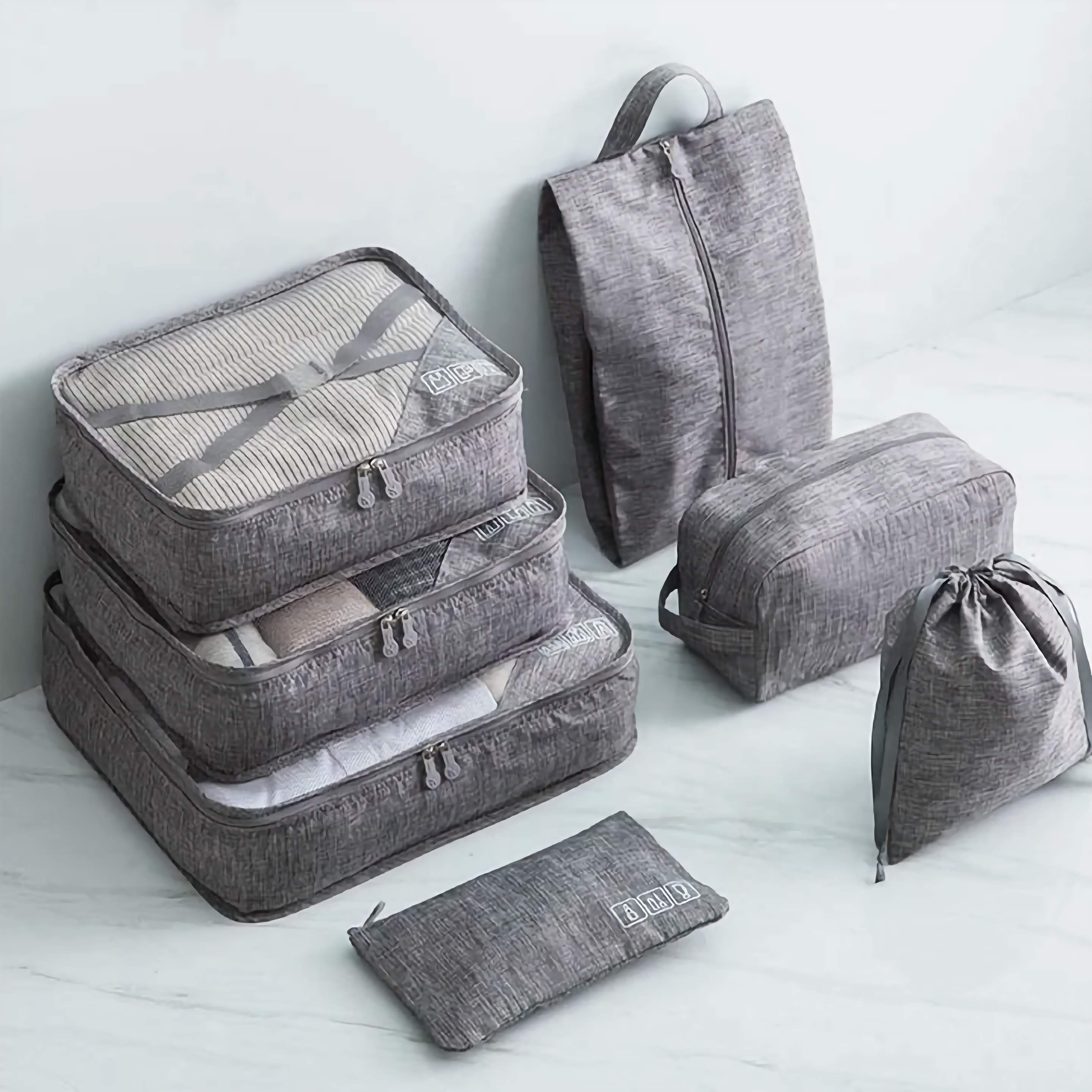 Set of gray packing cubes and bags on a light background